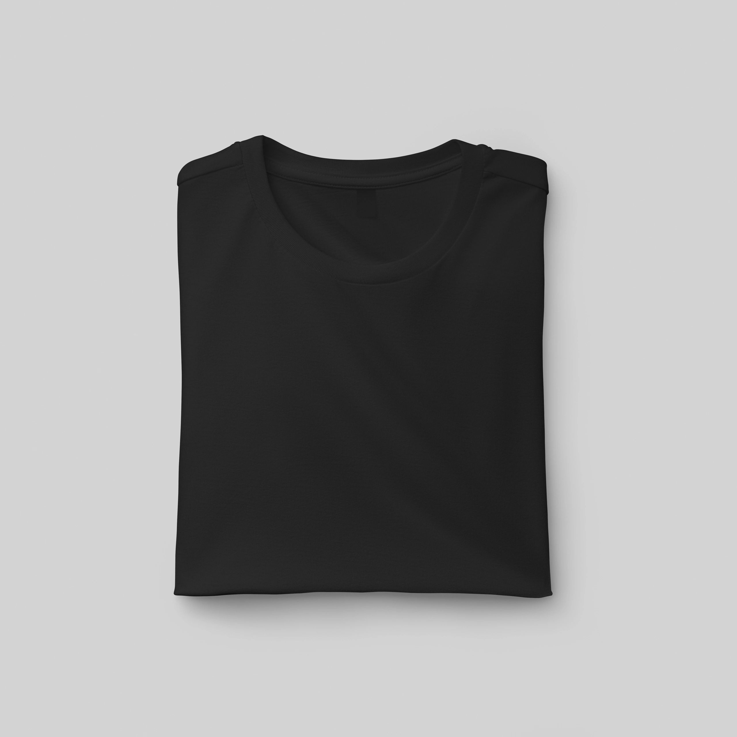Folded black t-shirt mockup with label on a clean background.
